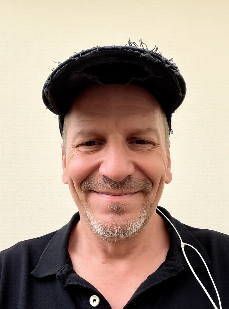 Portrait of H.G.O. Dillenberg, smiling, wearing a worn dark cap